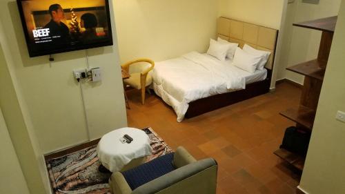 um quarto de hotel com uma cama e uma televisão em Stylish Studio apartment with Pool and Gym em Dar es Salaam