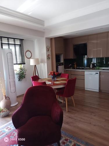 a living room with a table and chairs and a kitchen at Dublex house - near the Airport and sea and in the city in Dalaman