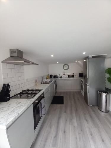 a kitchen with white counters and a stove top oven at NO 27 Apartment in Llandudno