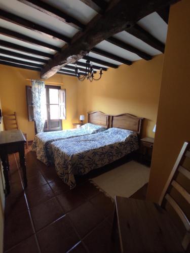 a bedroom with a bed with a blue comforter at La casina del pozo en Cudillero, As. VV-360-AS in Cudillero