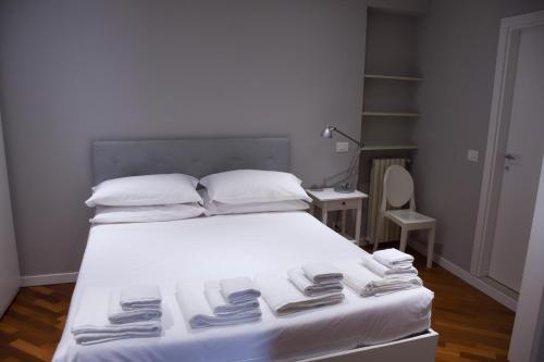 a bedroom with a white bed with towels on it at Collegio di Spagna 13 in Bologna