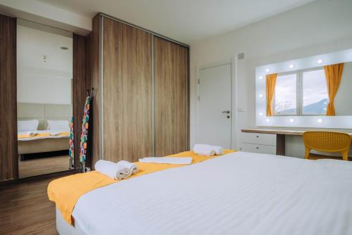 a bedroom with a large white bed and a desk at Darki Comfort Apartments - Stylish and Comfortable Apartments with Free Parking in Ohrid