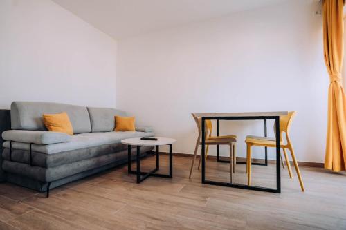 a living room with a couch and a table and chairs at Darki Comfort Apartments - Stylish and Comfortable Apartments with Free Parking in Ohrid