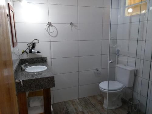 a bathroom with a toilet and a sink at POUSADA AURORA in Mundo Novo