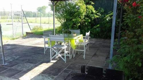 a yellow table and chairs on a patio at Plumpton Barn in Ashford