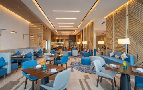 a restaurant with blue chairs and tables and tablesktop at Holiday Inn Express Lanzhou New Area, an IHG Hotel in Lanzhou