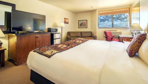 a hotel room with a large bed and a flat screen tv at Ticaboo Lodge in Ticaboo