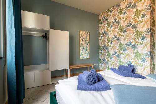 a bedroom with a bed with blue towels on it at LOFT TIRANO 3min walk to BerninaExpress in Tirano