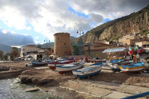 a group of boats sitting on the sand near a building at Room Sixty One in Palermo