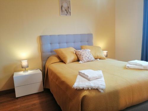 a bedroom with a bed with two towels on it at Duplex da Fontinha in Santa Cruz