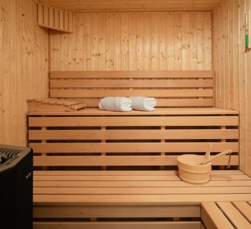 uma sauna com duas toalhas e um balde em Villa Ramarin III with infinity heated pool, jacuzzi and sauna by the sea in Rogoznica em Rogoznica