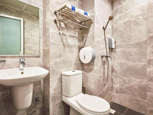 a bathroom with a toilet and a sink at ibis budget Singapore Sapphire in Singapore