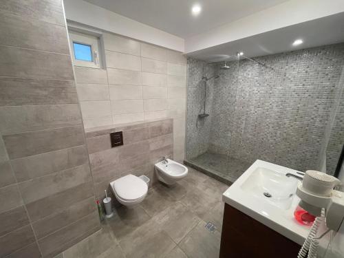 La salle de bains est pourvue de toilettes, d'un lavabo et d'une douche. dans l'établissement TANIA Lake Apartments, à Mamaia