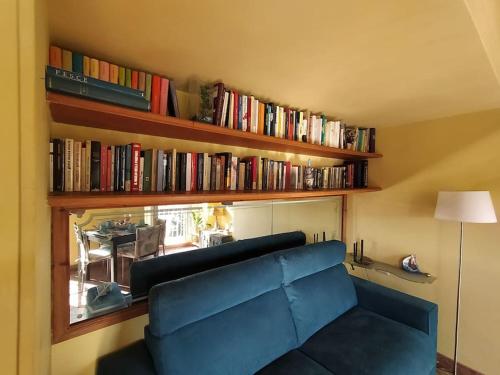 a living room with a blue couch and books at Il Vecchio e il Mare in Fiumicino
