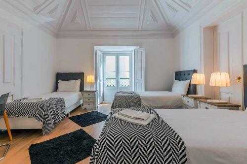 a white room with two beds and two tables at Bairro Alto Palace Special for Groups up to 24 guests in Lisbon