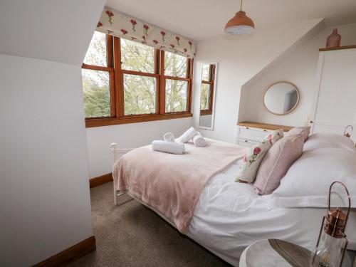 a bedroom with a white bed and a window at Clearwater House in Lochailort