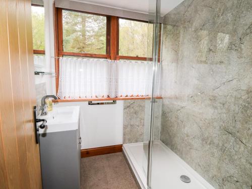 a bathroom with a shower and a sink at Clearwater House in Lochailort