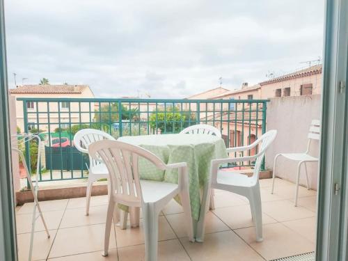 une table et des chaises assises sur un balcon dans l'établissement La Garde appartement deux pièces, à La Garde