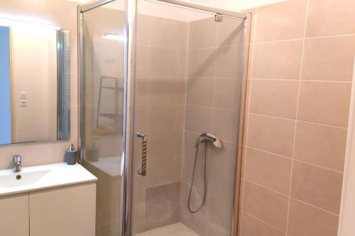 une douche avec une porte vitrée à côté d'un lavabo dans l'établissement La Garde appartement deux pièces, à La Garde