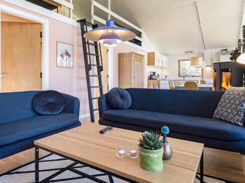 a living room with two blue couches and a table at 7 person holiday home in Skals-By Traum in Skals