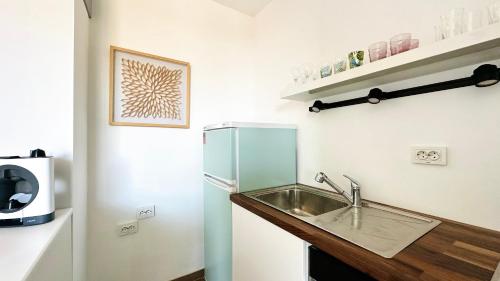 a small kitchen with a sink and a refrigerator at APARTELLO Modern Apartment - Garden of Eden in Sveti Vlas