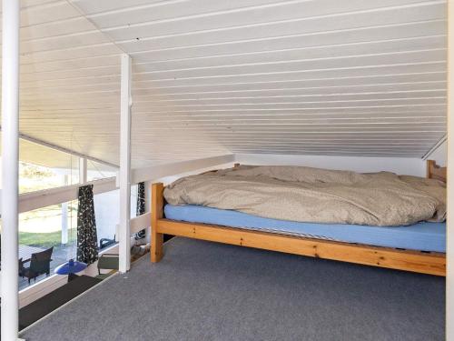 Bett in einem Zimmer mit einer weißen Wand in der Unterkunft Holiday home Skals VI in Skals