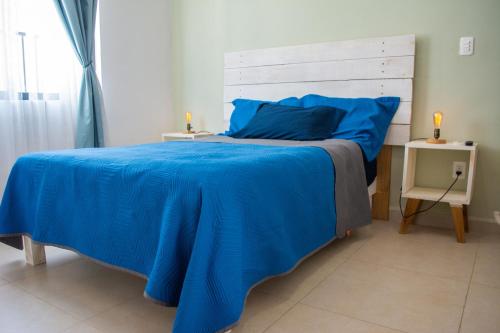 - une chambre avec un lit bleu et une tête de lit en bois dans l'établissement Paraíso Playa Bonita- Roof Top, à Playa del Carmen