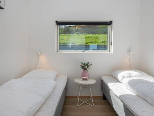 two beds in a room with a table and a window at 6 person holiday home in Lemvig-By Traum in Lemvig
