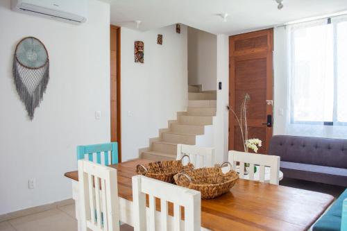 una sala da pranzo con tavolo e sedie in legno di Paraíso Playa Bonita- Roof Top a Playa del Carmen