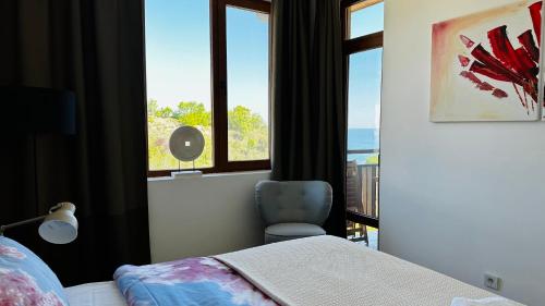a bedroom with a bed and a window and a chair at APARTELLO Modern Apartment - Garden of Eden in Sveti Vlas