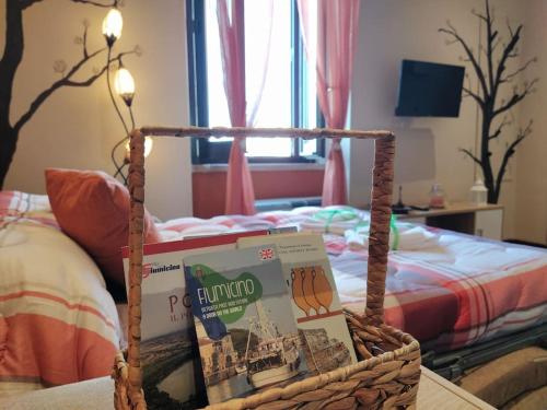 a wicker basket with a book on top of a bed at Casa degli Alberi in Fiumicino