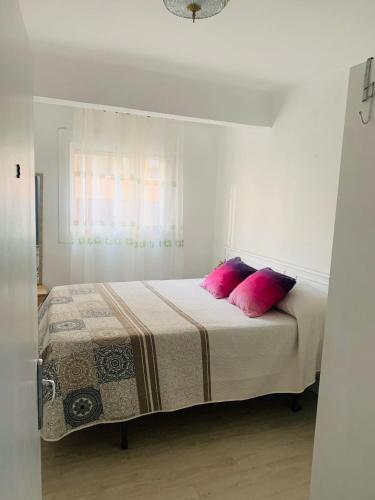 a bedroom with a bed with two pink pillows at Cosy Private Room in Valencia