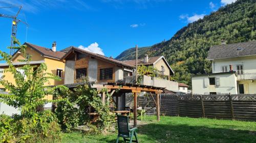 a house with a wooden deck in a yard at Chez Pewee, beau duplex en ville, parc privé in Martigny-Ville