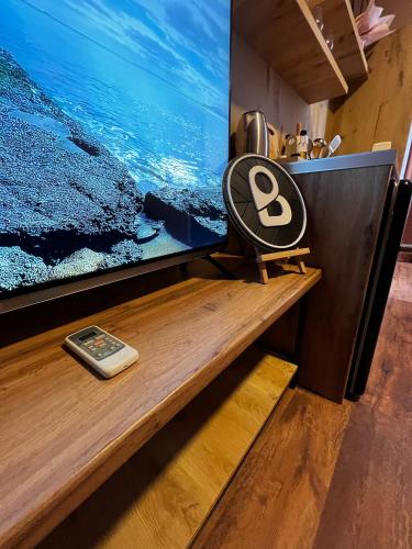 a tv sitting on top of a wooden table with a remote control at BejartApartment2 in Tirana