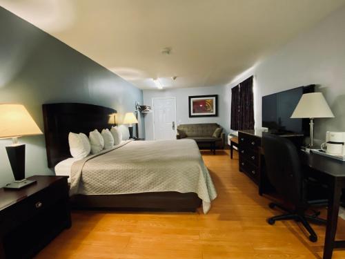 a hotel room with a bed and a desk and a chair at Kenora Motel in Windsor