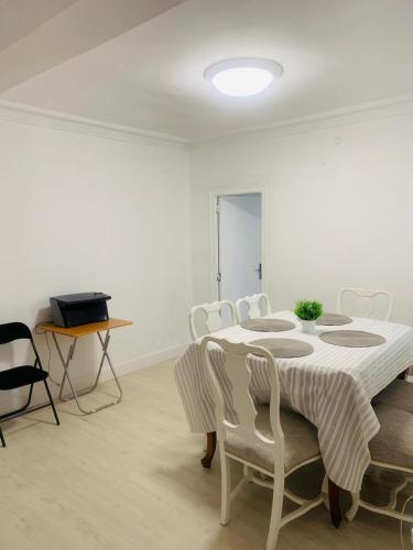 a white dining room with a table and chairs at Cosy Private Room in Valencia
