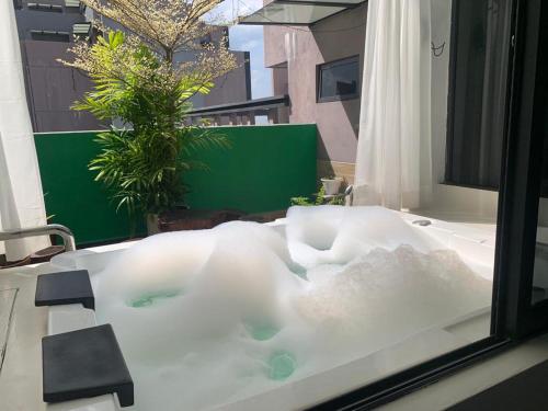 a bath tub filled with water next to a window at lmperio Residence Melaka - Private Indoor Hot Jacuzzi in Melaka