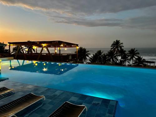 a swimming pool with the ocean in the background at Hotel El Guajataca in Quebradillas