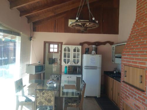 a kitchen with a table and a white refrigerator at Conforto e comodidade em Santa Maria in Santa Maria