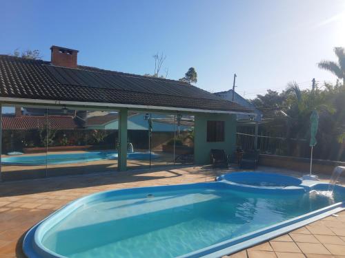 een zwembad in een tuin met een huis bij Conforto e comodidade em Santa Maria in Santa Maria