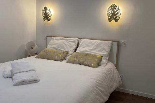 a bedroom with a white bed with two lights on the wall at * Logement Haut de gamme Centre * in Perpignan
