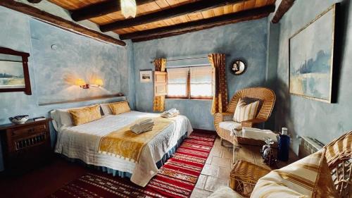 a bedroom with a bed and a chair at Cortijo El Pino Retreat in Albuñuelas