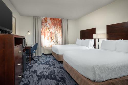 a hotel room with two beds and a desk at Fairfield by Marriott Tacoma Puyallup in Puyallup