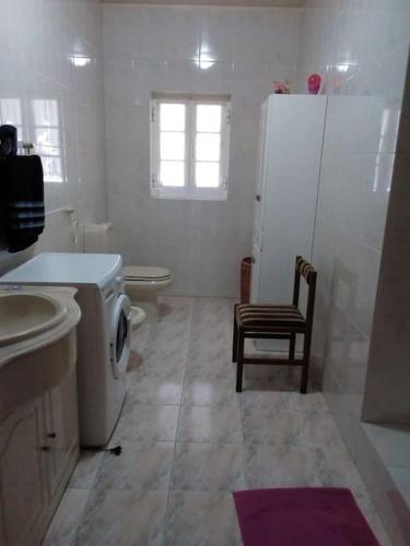 a bathroom with a toilet and a sink and a refrigerator at Férias felizes em família/com amigos in Março de Simães