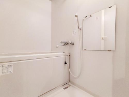 a white bathroom with a shower and a mirror at Classic/modern Japanese-style 2rooms/3mins to Sta/8P in Tokyo