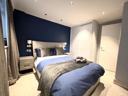 um quarto com uma cama grande e paredes azuis em London Duplex Apartment 2 bedroom with Terrace em Londres