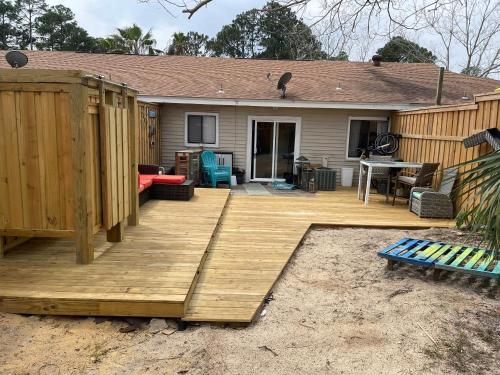 a wooden deck in front of a house at Destin-y 30A Beach Retreat Self Checkin - Huge Private Backyard Deck with Outdoor Shower in Santa Rosa Beach