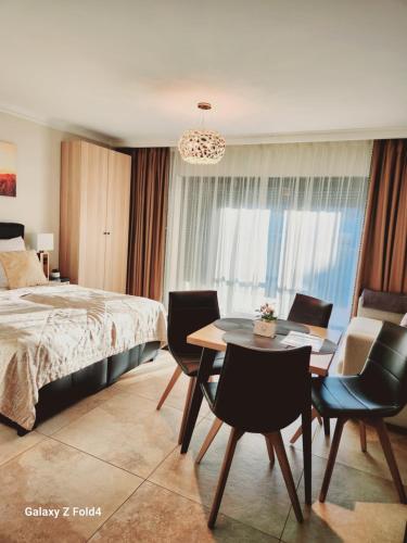 ジブヌフにあるEkskluzywny Apartament GOLD Gardenia Dziwnów z widokiem na morze trzecie piętro 1 pokojowy EPapartamentyのベッドルーム1室(ベッド1台、テーブル、椅子付)