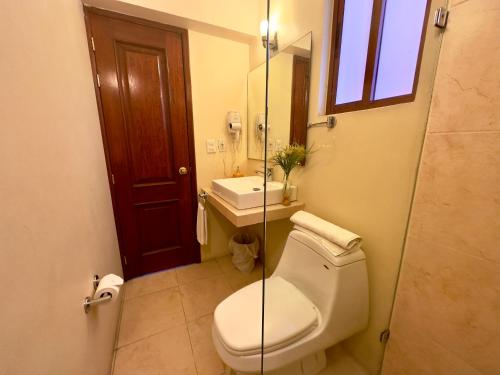 a bathroom with a toilet and a sink and a mirror at Quinta Roca Hotel in Oaxaca City