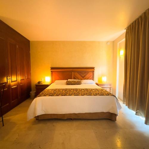 a bedroom with a large bed in a room at Hotel Quinta Roca in Oaxaca City
